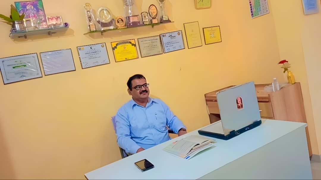 Bhaskar Vishnu Porje sitting at advisory desk in Nashik office